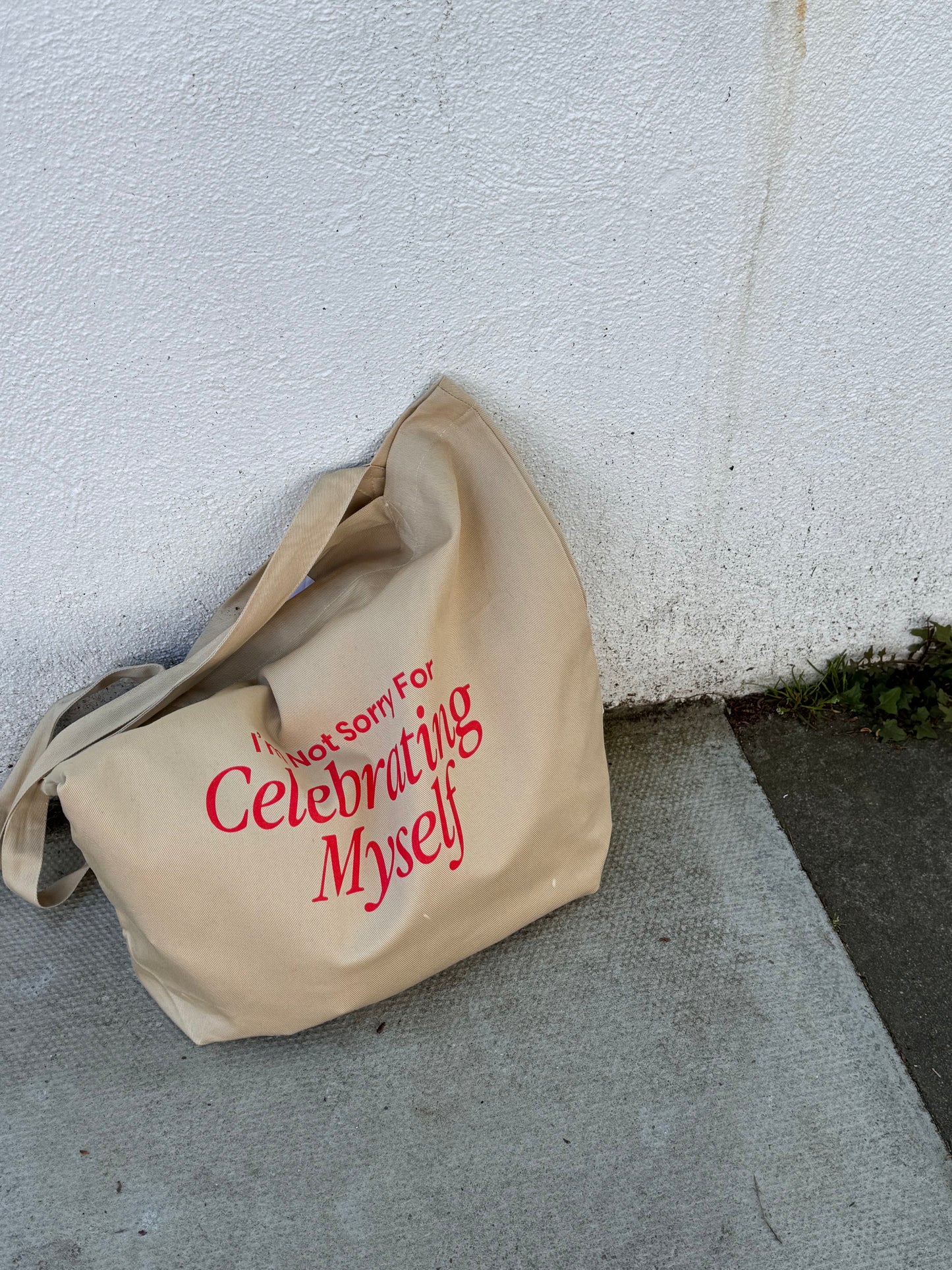 Ziyi Studio organic cotton tote bag featuring “I’m Not Sorry For Celebrating Myself” artwork. Cream-colored, ethically made, printed in Europe, with long straps and open main compartment