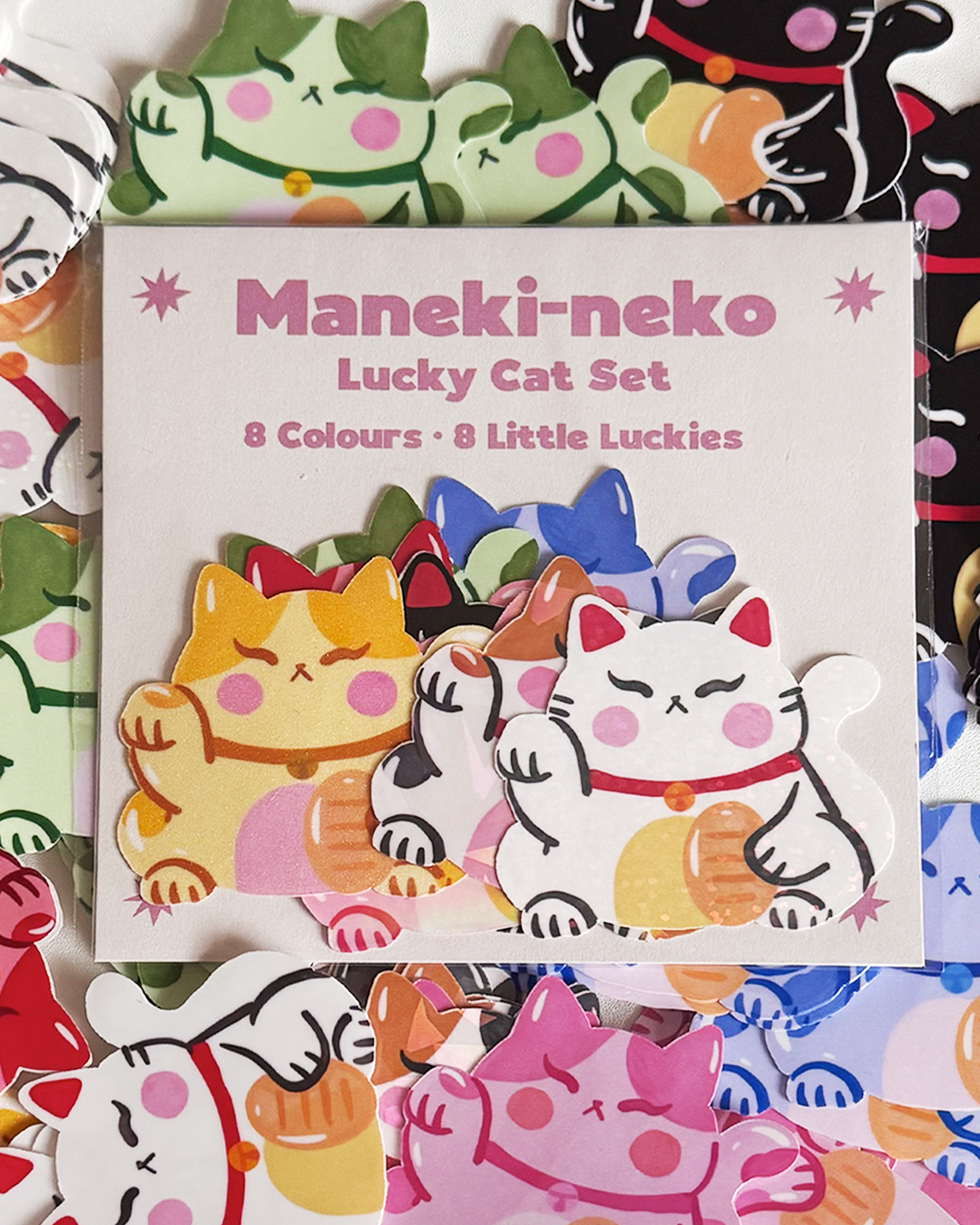 Complete Maneki-neko lucky cat sticker pack with 8 colors including white black blue pink red gold green tri-color by London artist