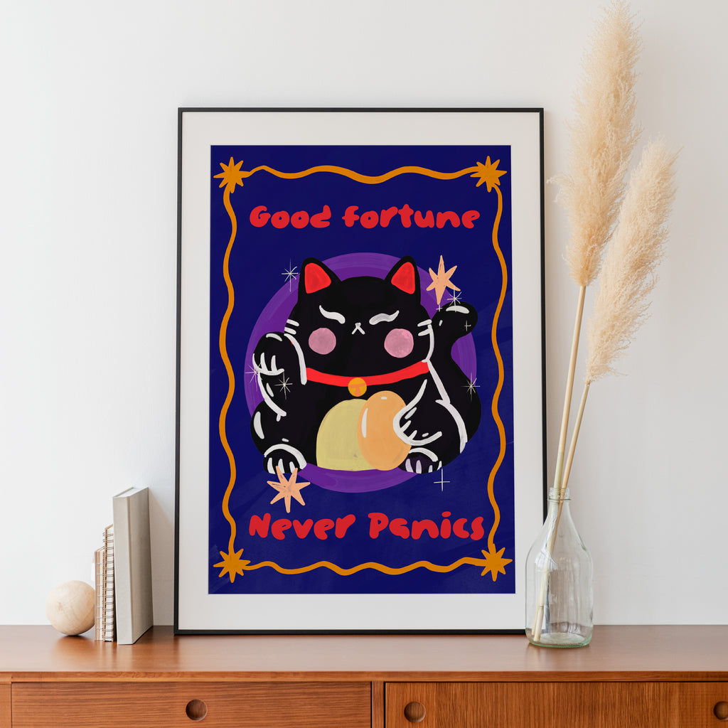 Framed artwork with a black cat illustration and text on a wall.