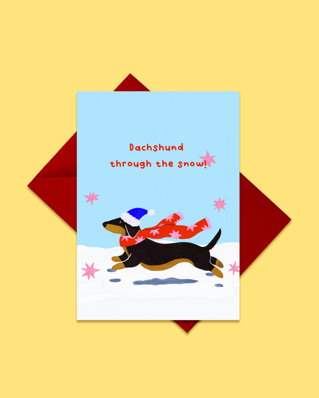 Dachshund Through the Snow greeting card with red envelope, sausage dog in santa hat design by London artist