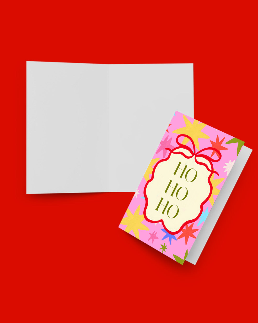 Ho Ho Ho card held in hand against a green velvet curtain backdrop