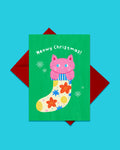 Meowy Christmas greeting card with red envelope, pink cat in floral stocking design by London artist