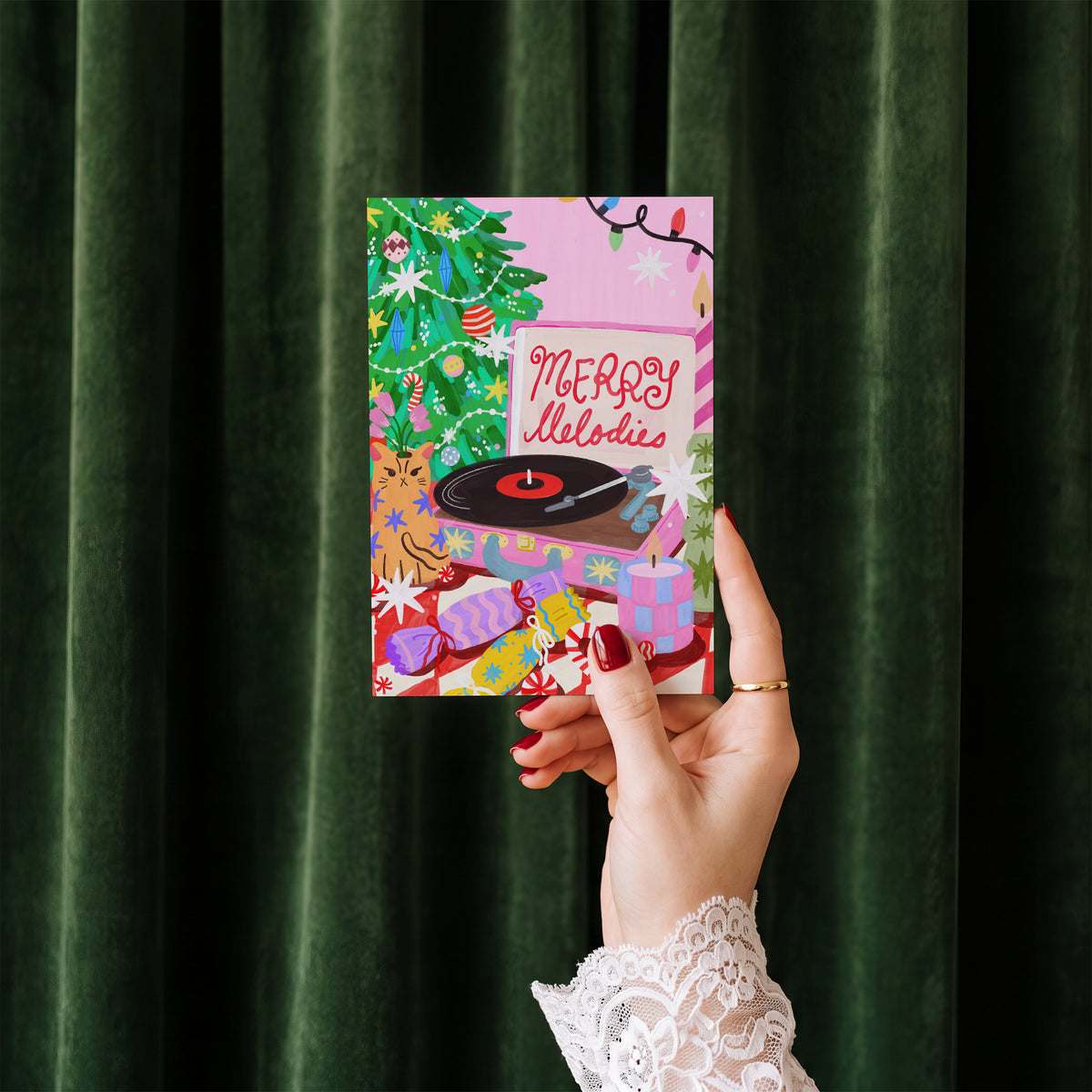 Merry Melodies card held in hand against a green velvet curtain backdrop