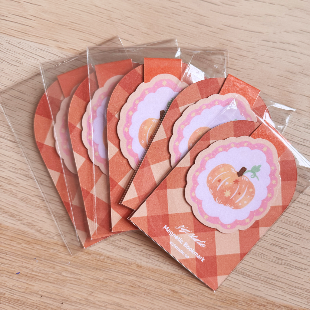 Set of small envelopes with pumpkin designs on a wooden surface