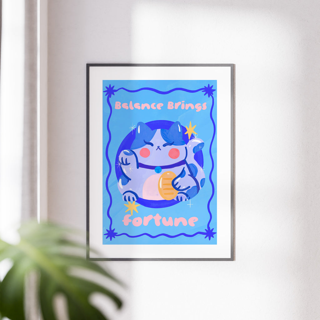 Framed artwork with a cartoon cat and text on a blue background, displayed on a wall.