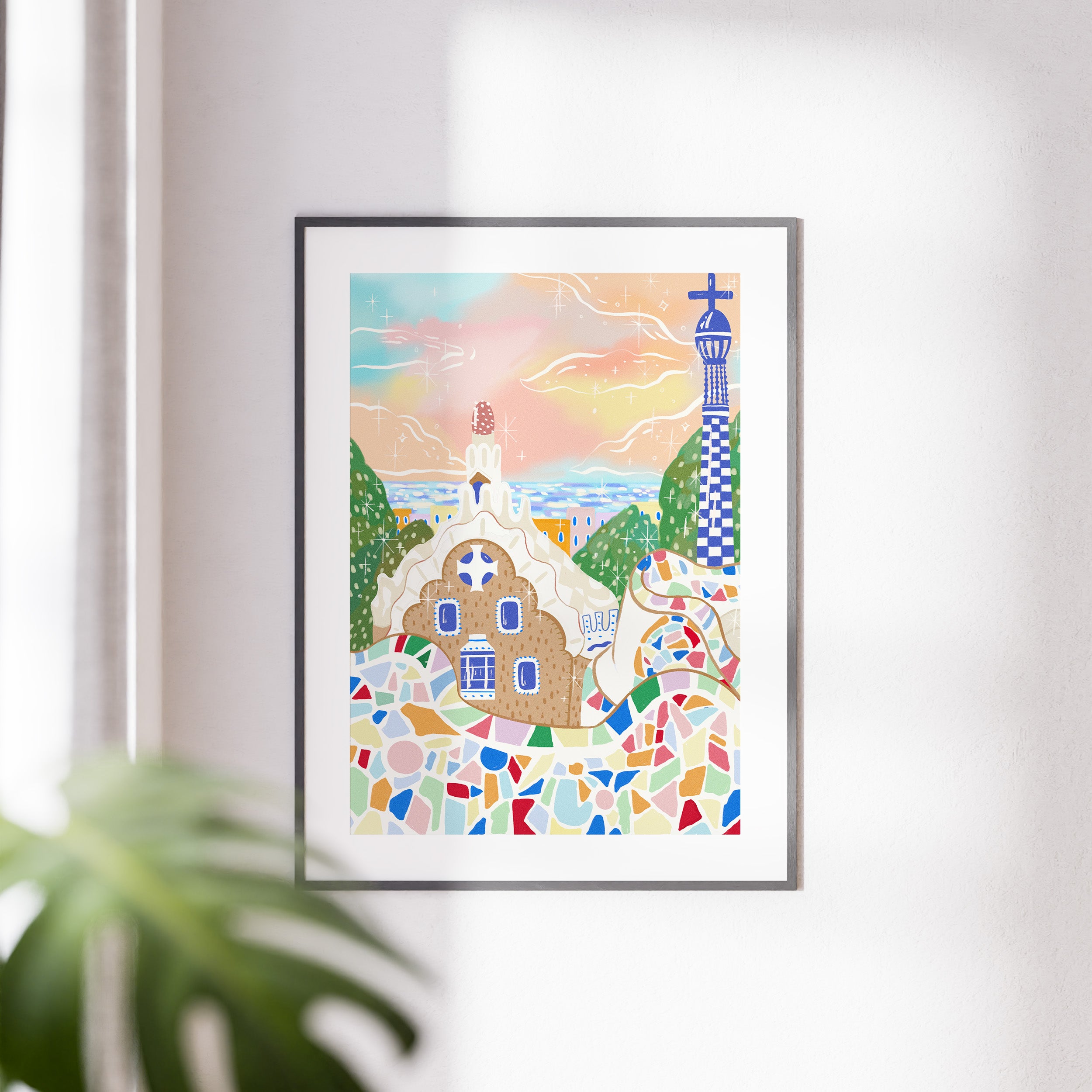 Framed Barcelona art print displayed on interior wall, showcasing colorful Park Güell-inspired mosaic design in a cozy home setting.