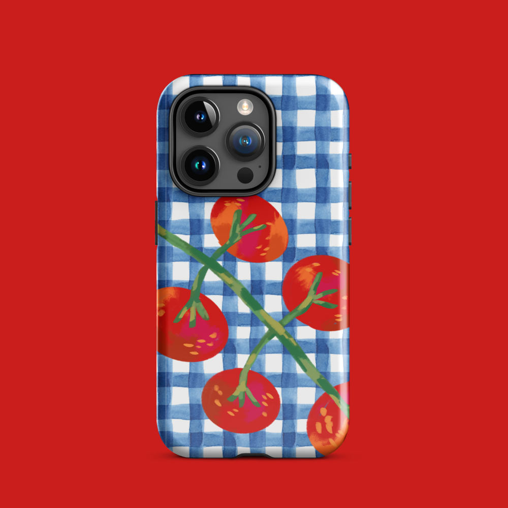 Close-up of cherry tomato phone case with blue gingham pattern on red background, showing back design and camera cutout.