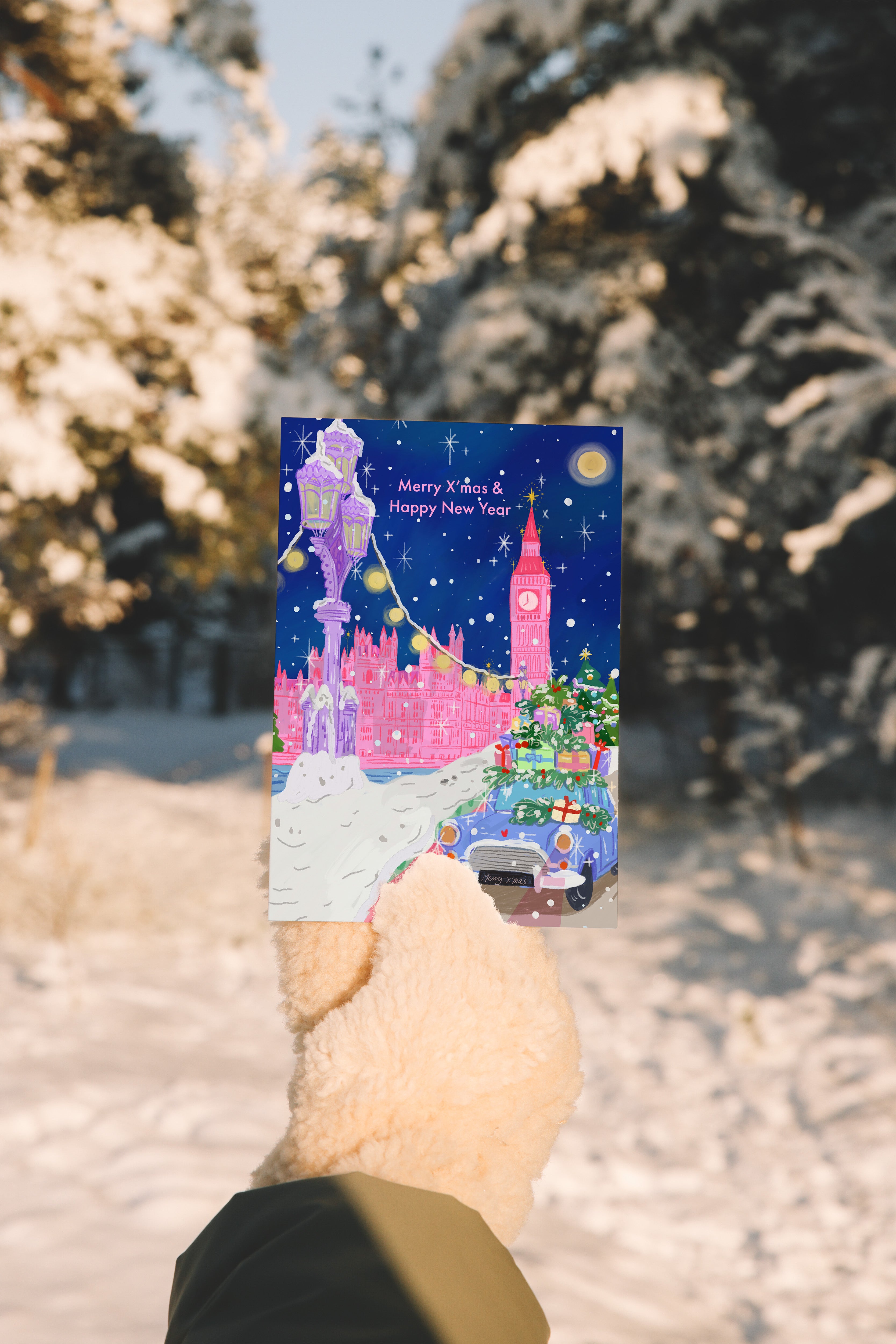 Hand holding a phone with a festive screen against a snowy background