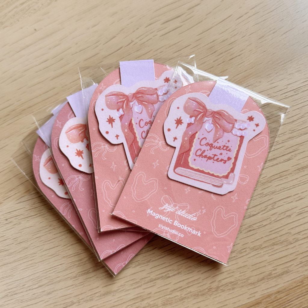 Set of pink magnetic bookmarks with decorative designs on a wooden surface