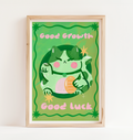 Framed artwork with a green creature illustration and text 'Good Growth' and 'Good Luck' on a green background.
