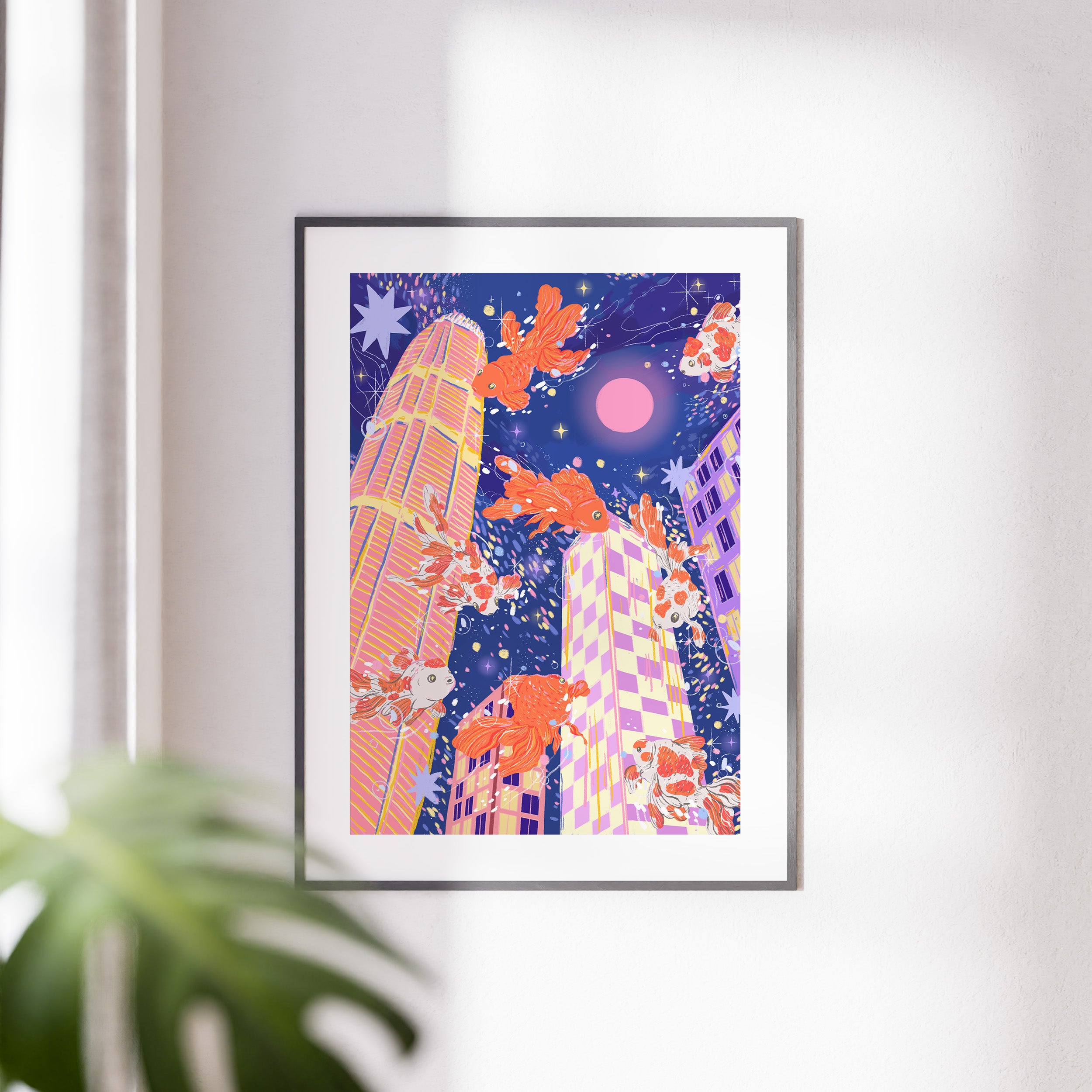 Framed wall art of goldfish swimming above Hong Kong skyline under pink moon