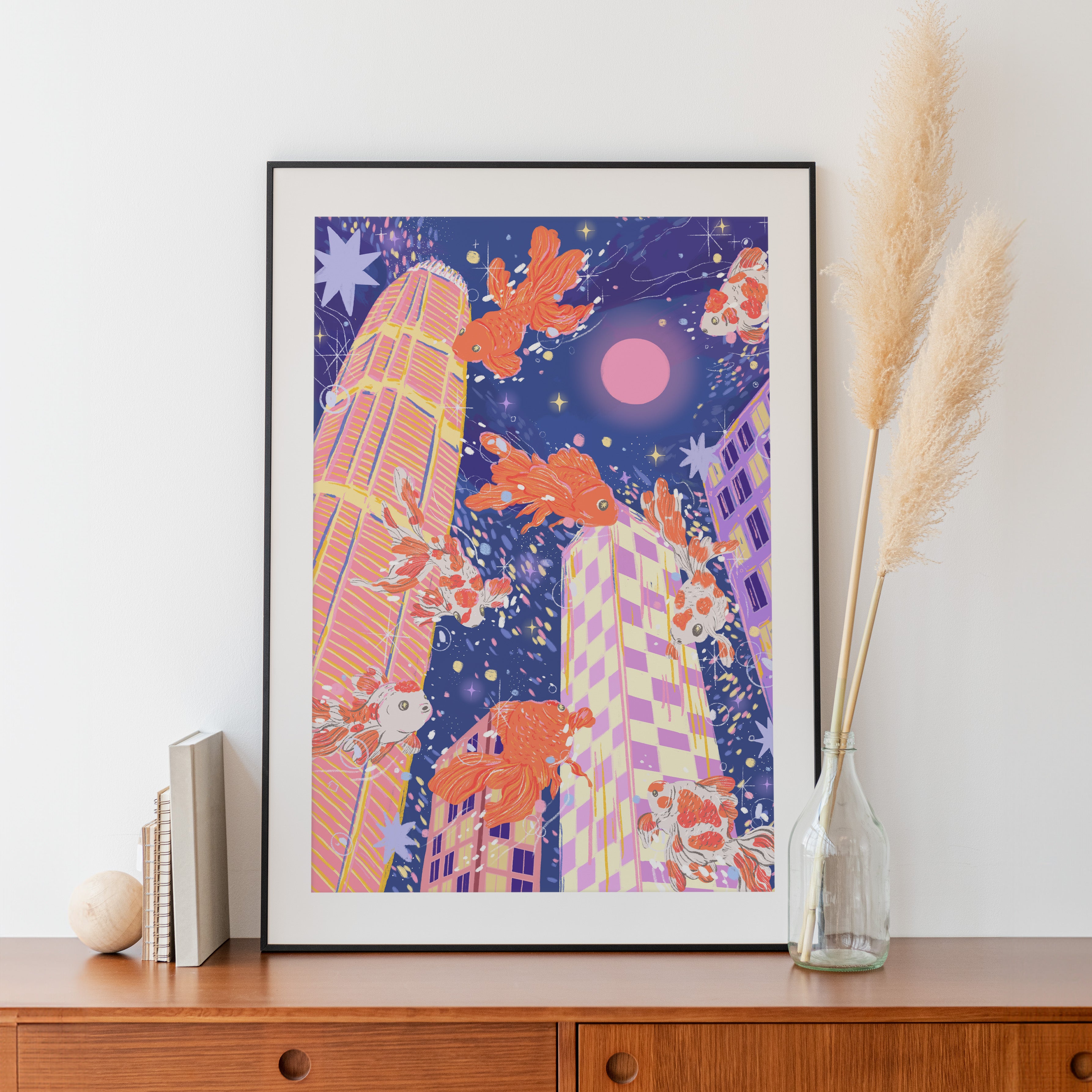 Large framed print of goldfish floating above pastel skyscrapers – dreamy city view