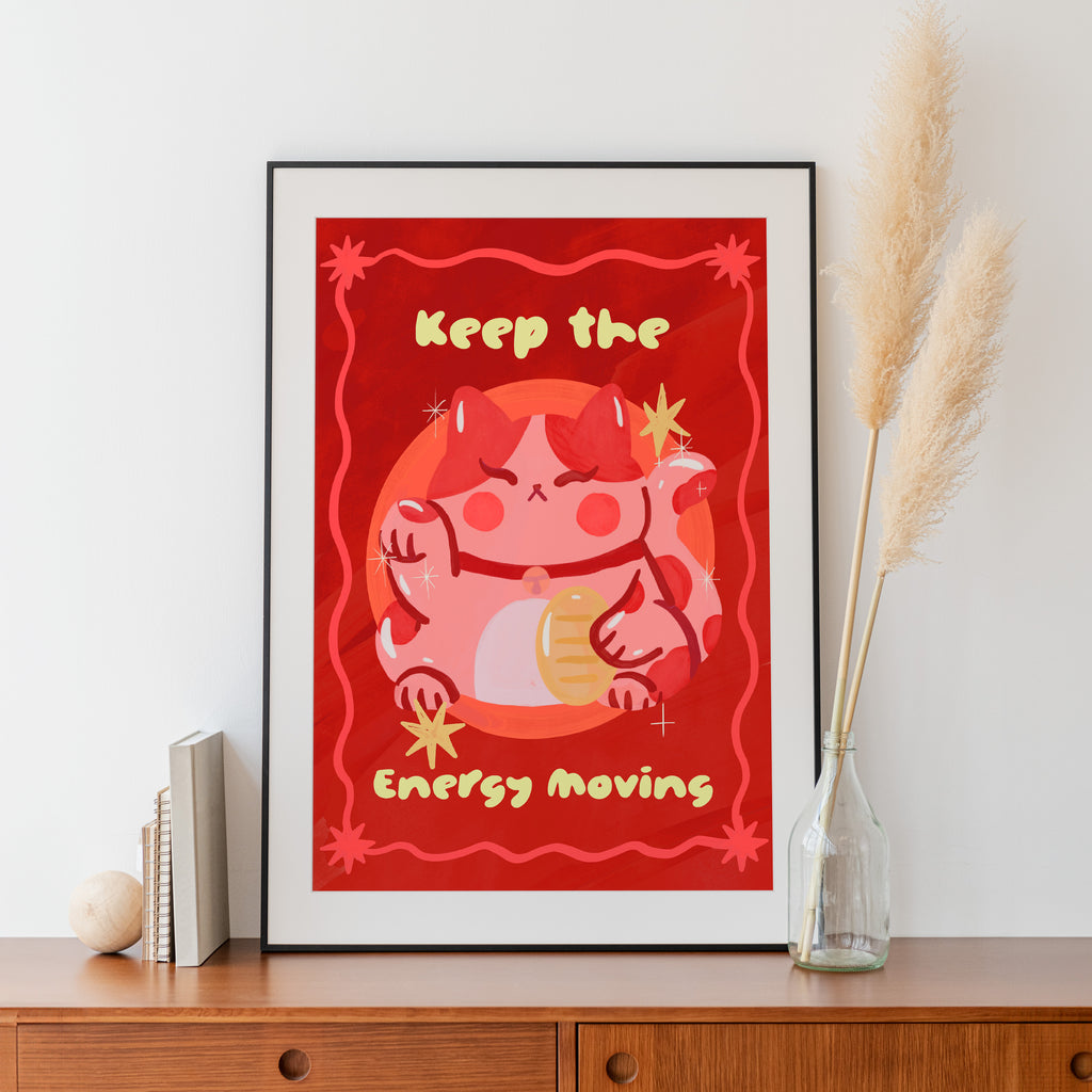 Framed artwork with a red background and cartoon character, placed on a wooden surface.