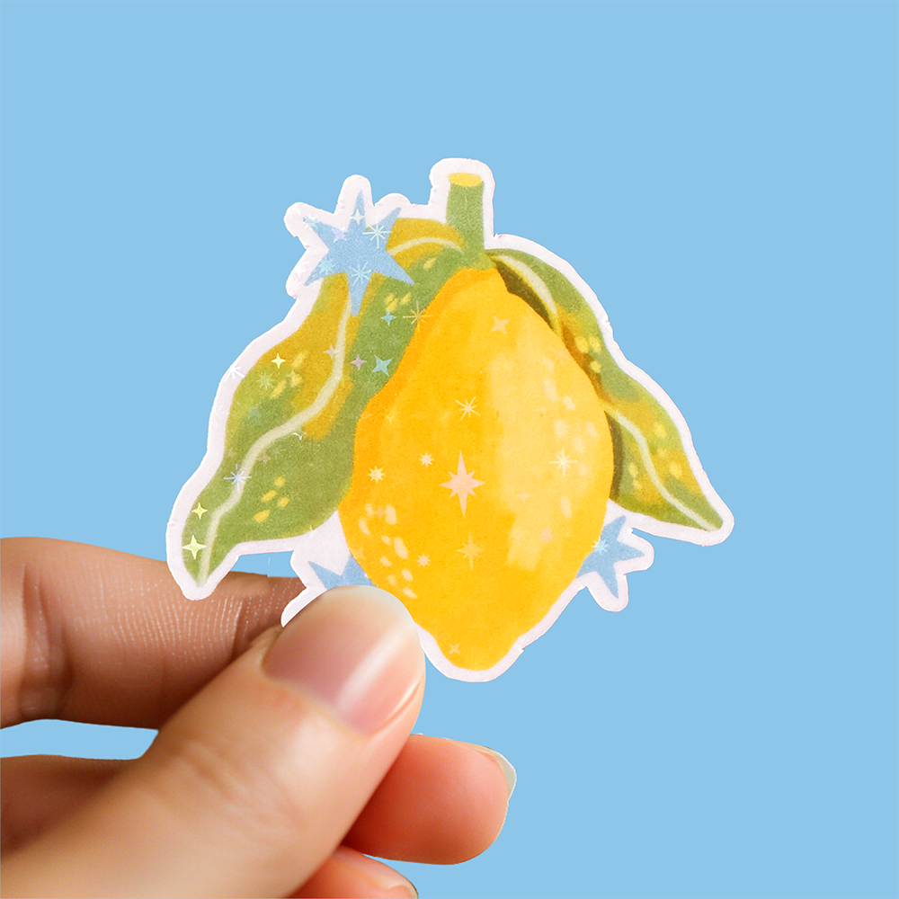 Glossy sparkly vinyl lemon sticker with hand-drawn illustration. Cute and zesty, perfect for summer stationery or decorating bottles and planners.