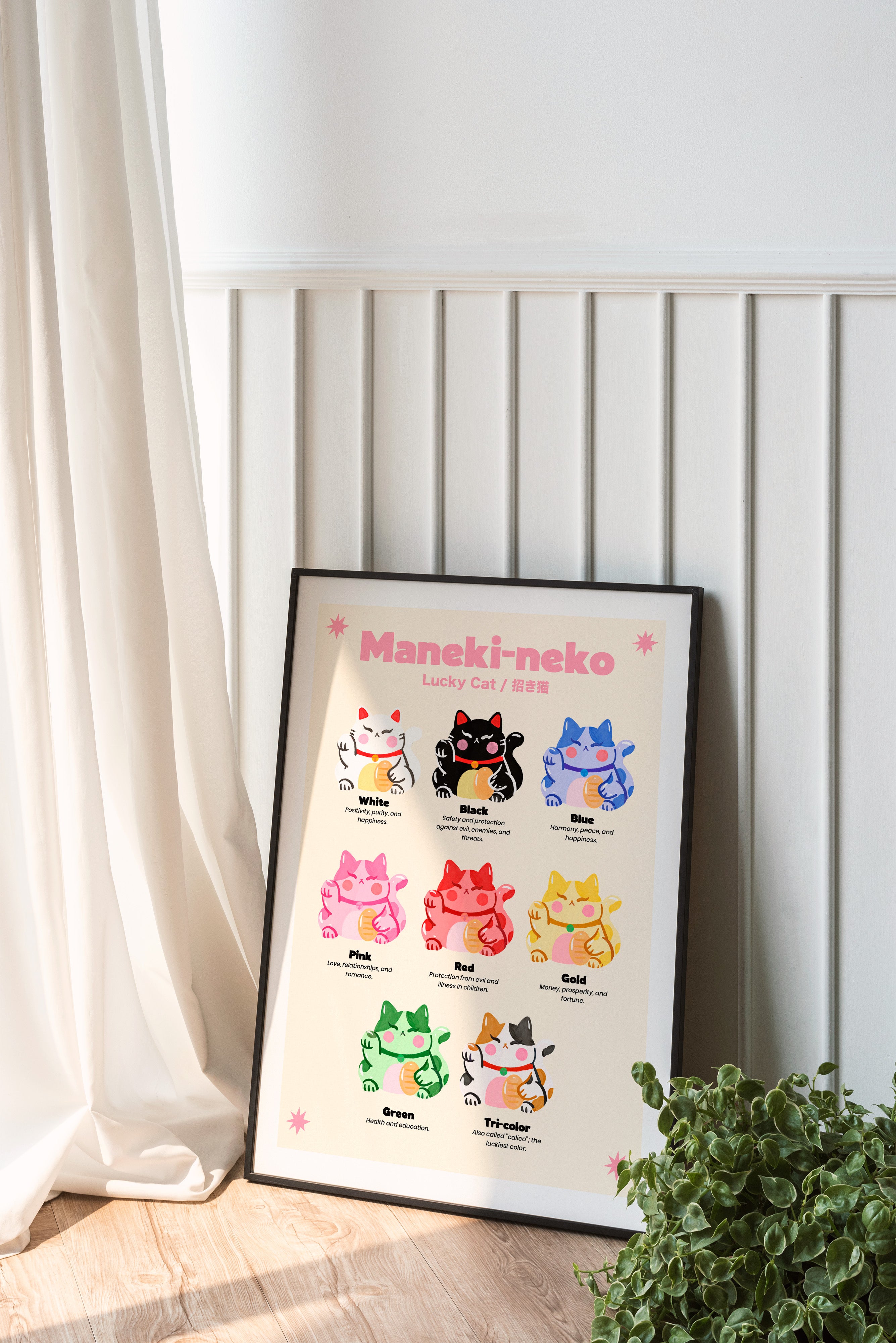 Framed Maneki-neko poster on a wall with a plant and curtain in the foreground