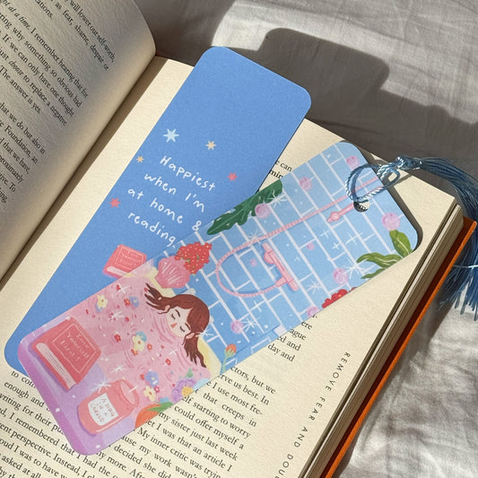 Handmade double-sided bookmark titled “Manifest & Relax,” featuring a cozy self-care illustration on the front and the quote “Happiest when I’m at home & reading” on the back. Matte finish with optional tassel.