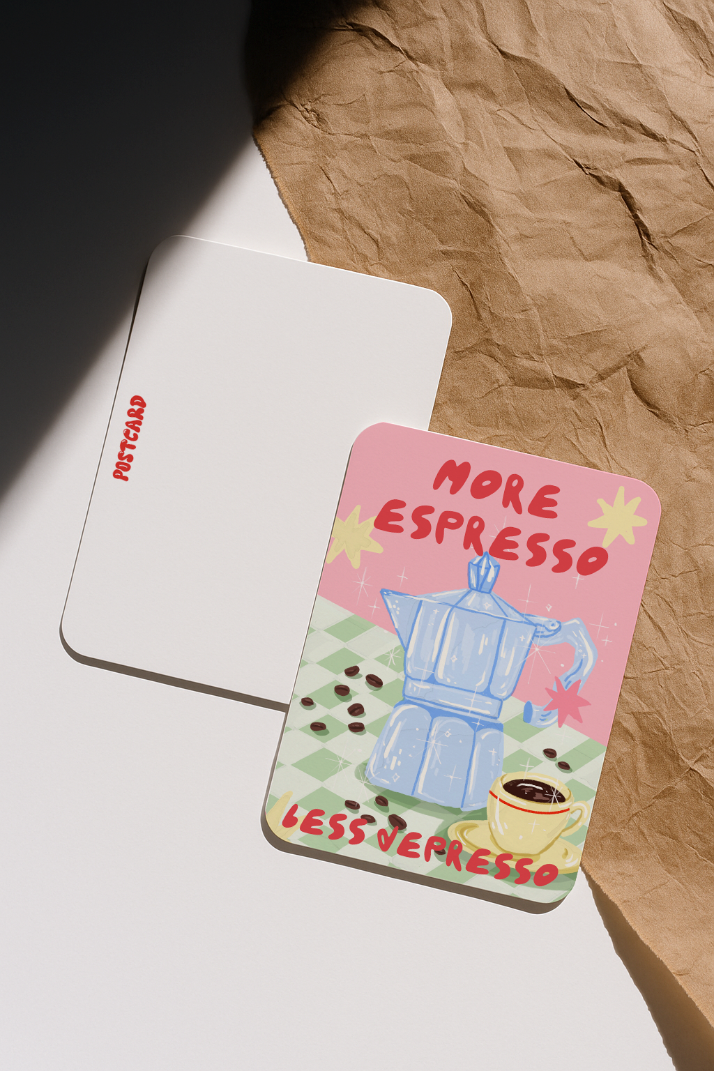 Close-up of front and back of More Espresso Less Depresso postcard on crumpled paper background