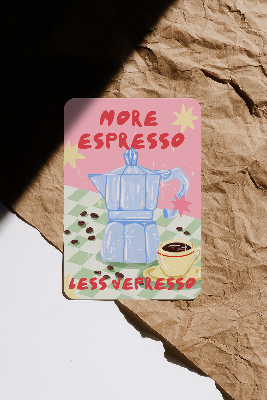 More Espresso Less Depresso postcard lying on kraft paper with sunlight casting shadows
