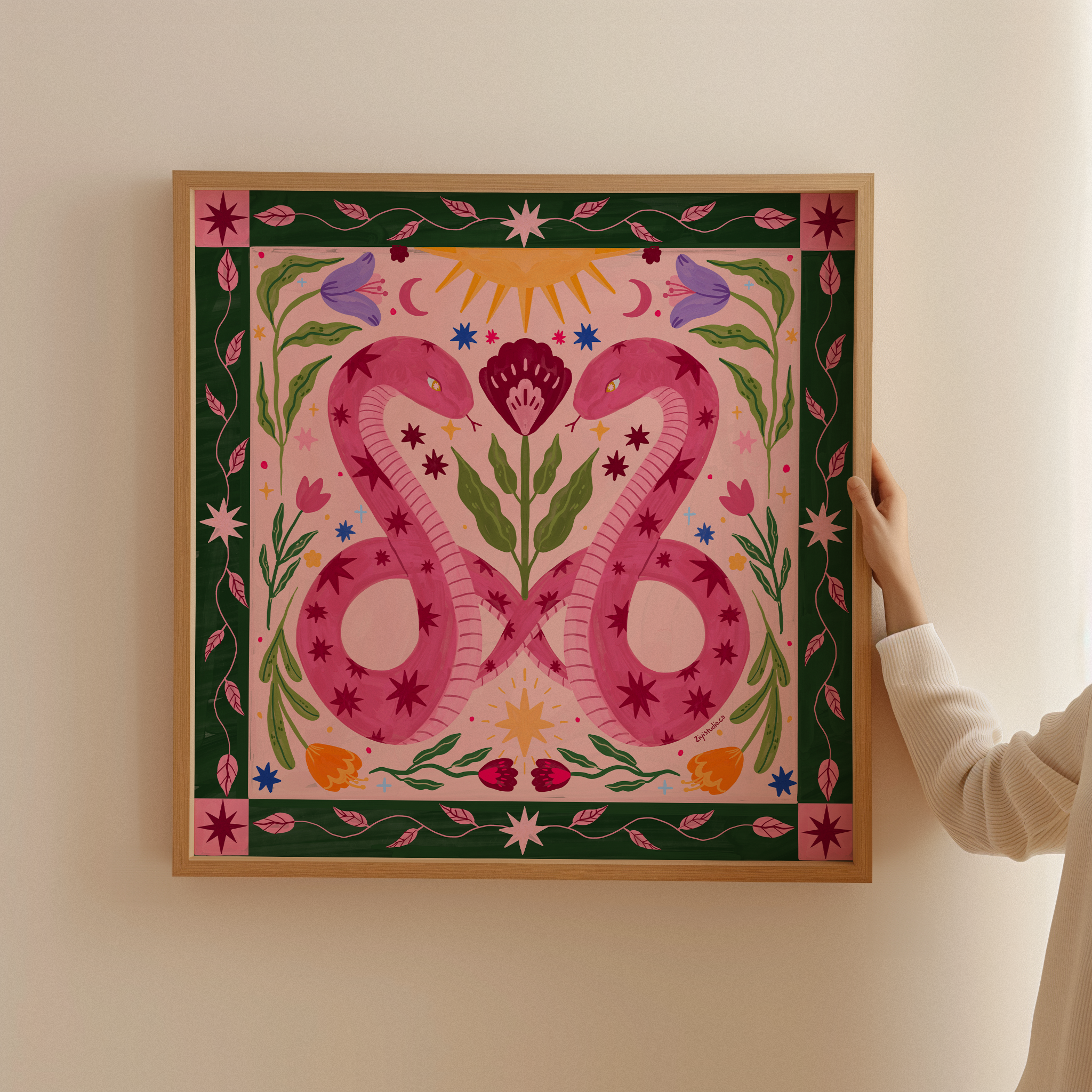 Mystical twin snakes folk art print in oak frame by London artist, featuring celestial stars and green decorative border