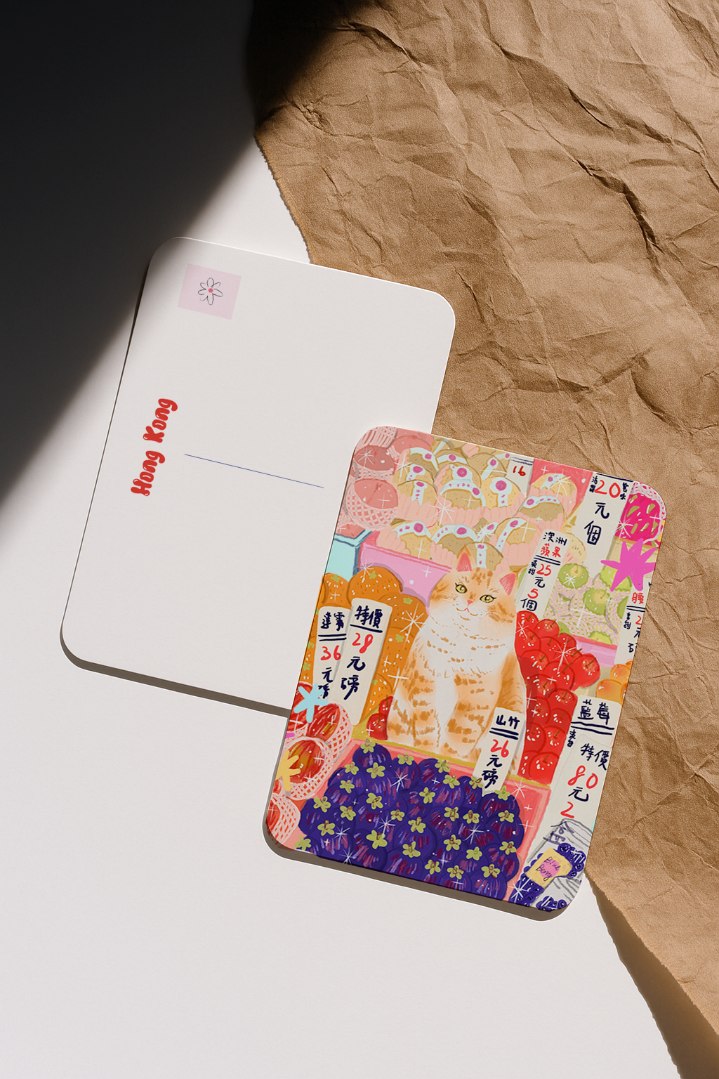 Colorful card with cat illustration on a white surface with brown paper