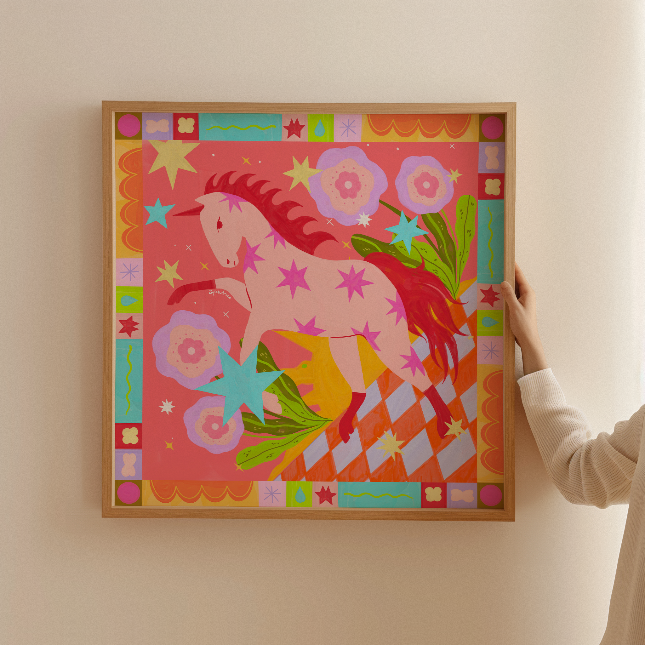 Close up of colourful pink horse art print showing bold geometric patterns, stars, and flowers in oak frame