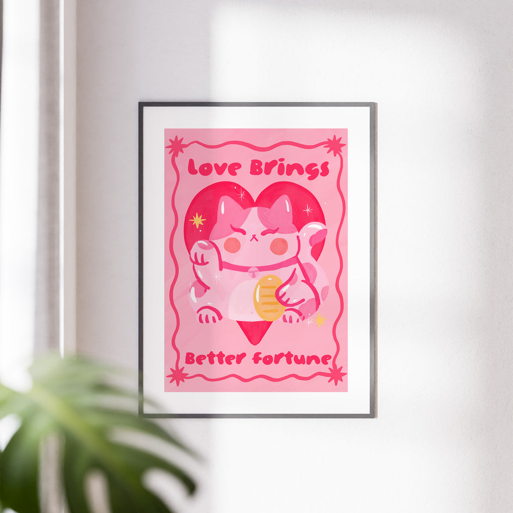 Framed artwork with a cartoon character and text on a pink background, placed on a white wall.