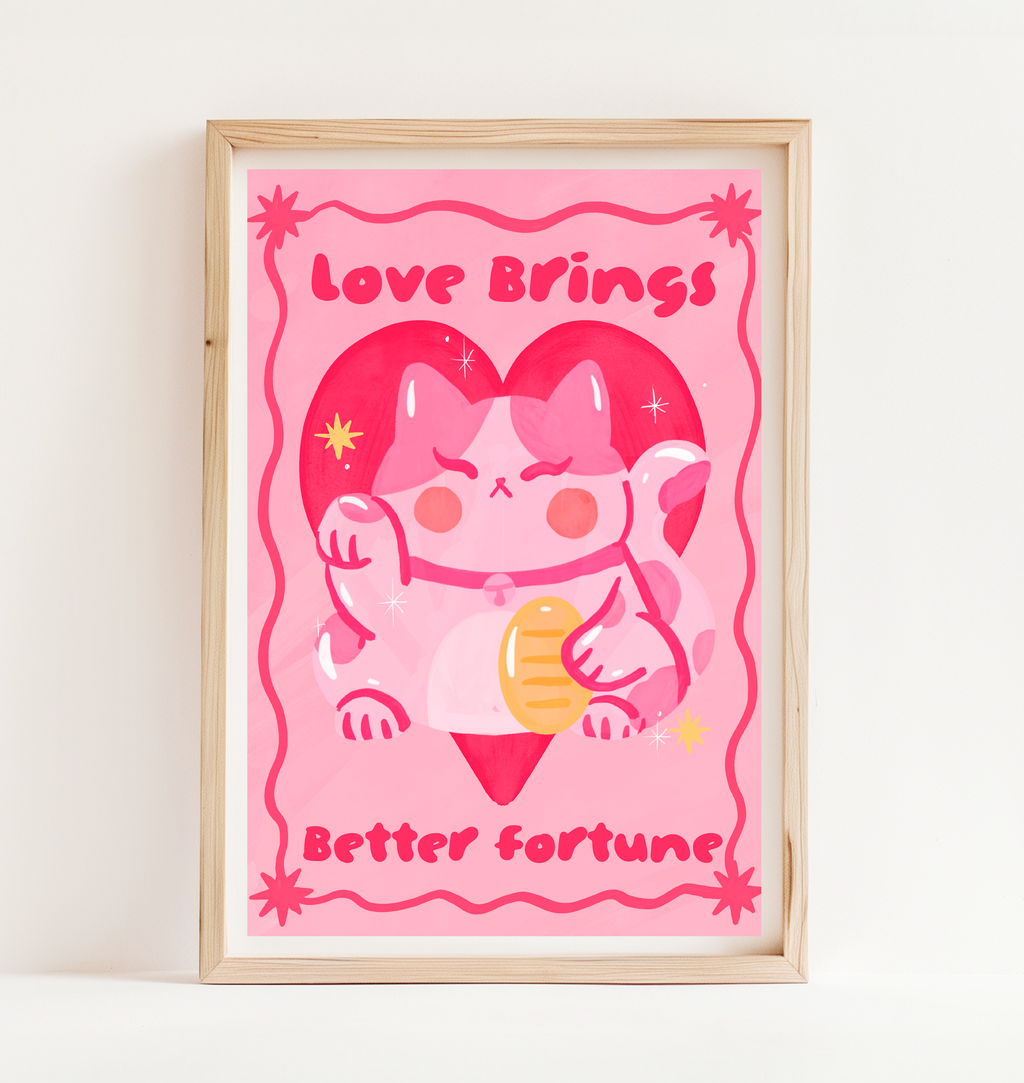 Framed artwork with a cartoon cat holding a heart and text 'Love Brings Better Fortune' on a pink background.