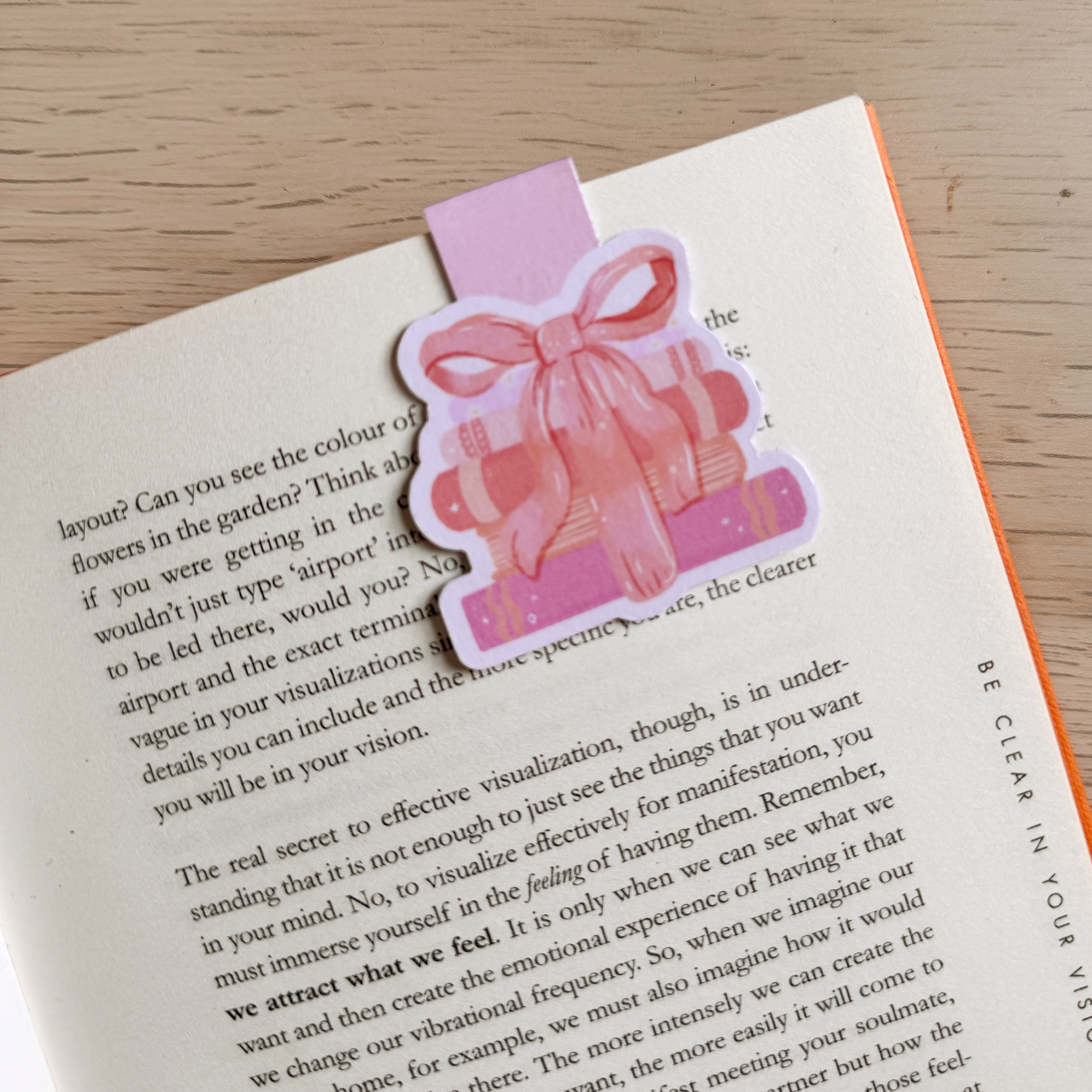Pink gift-shaped bookmark on an open book