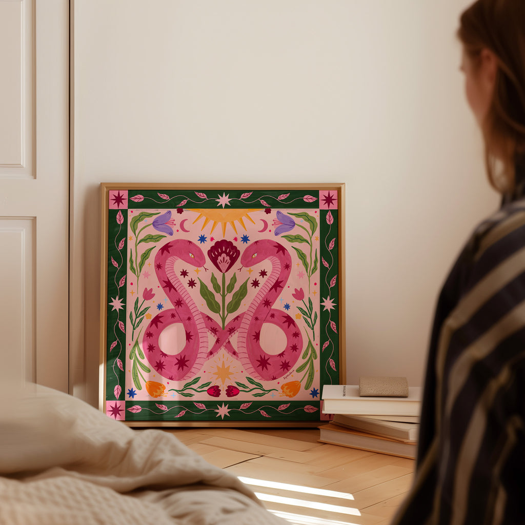 Person looking at a colorful painting of two pink snakes on a wall