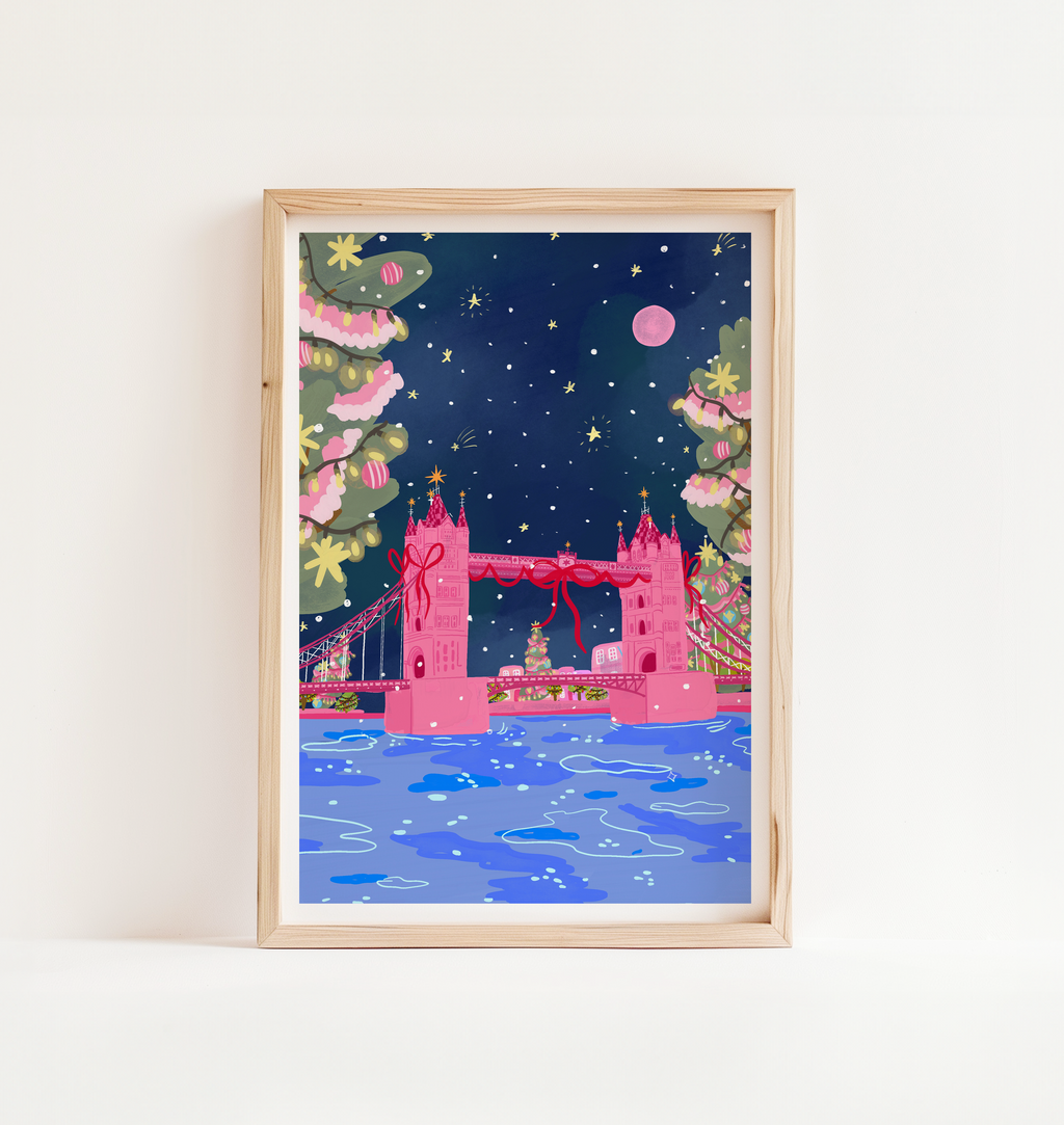 Framed artwork of a festive London Bridge with Christmas trees and decorations on a white wall.