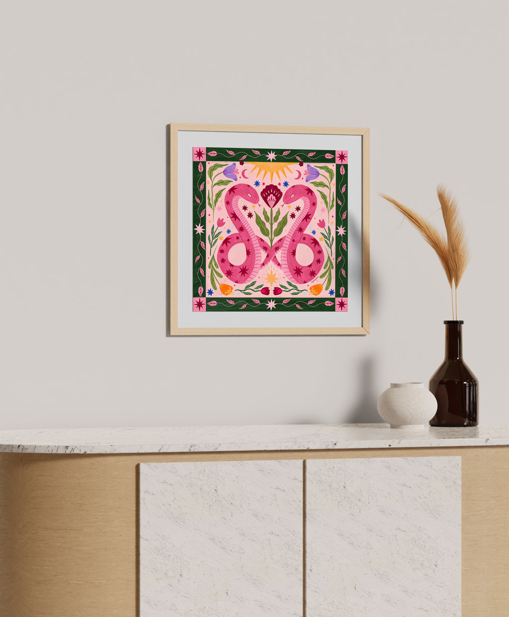 Framed artwork with floral design on a wall above a cabinet.