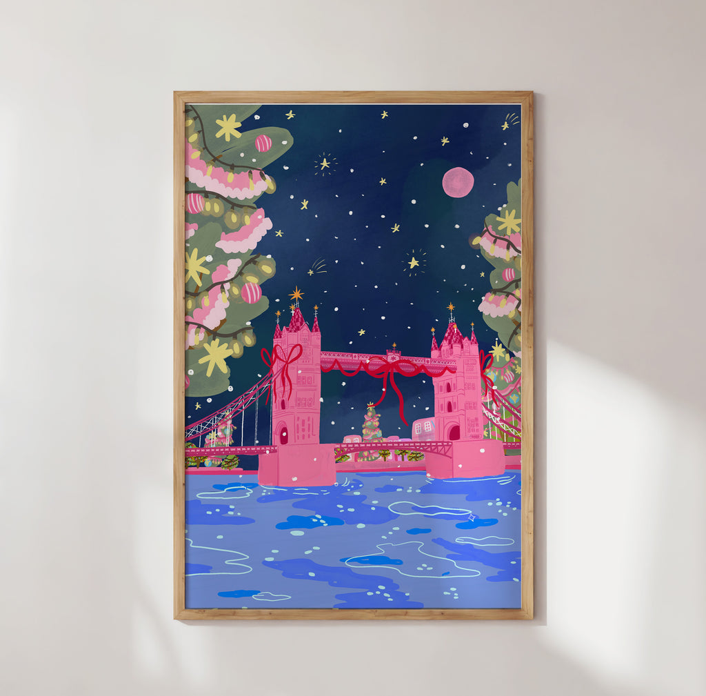 Framed artwork of a pink London Bridge with festive decorations on a white wall.